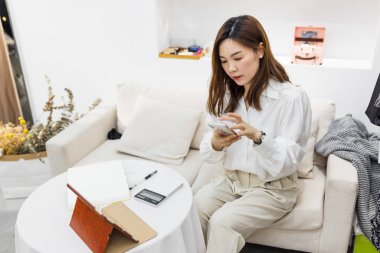 Küçük bir iş kurun, akıllı telefon ya da tablet kullanan Çinli genç girişimci paket ürün kutusu hazırlamak için online alışveriş siparişlerini alıp kontrol edin. çevrimiçi satış kavramı