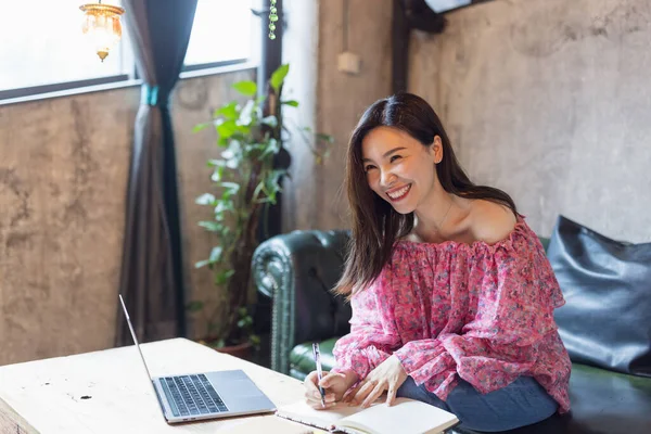Bastante joven asiático negocios mujer usando laptop en moderno café. — Foto de Stock