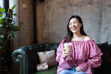 Modern kafede buzlu kahve içen güzel bir Asyalı kadın.. 