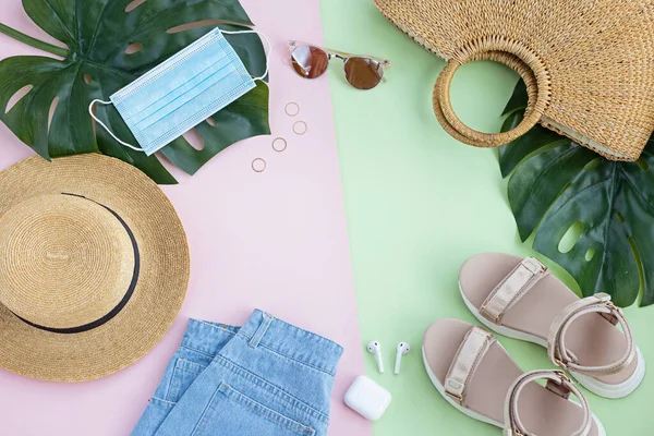 Composición de verano con atuendo de moda femenina. Hojas de monstera, sombrero de paja, bolsa de bambú, zapatos, auriculares inalámbricos sobre fondo pastel. plano, vista superior, arriba, maqueta, plantilla, espacio para copiar —  Fotos de Stock