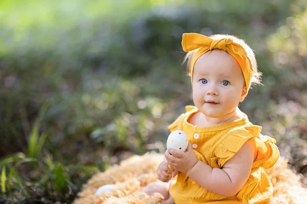 Portret uroczej białej dziewczynki sprzed 10 miesięcy bawiącej się w letnim parku. Stylowe niemowlę z blond włosami i niebieskimi oczami w modnej odzieży. Szczęśliwego dzieciństwa i opieki zdrowotnej dla dzieci — Zdjęcie stockowe