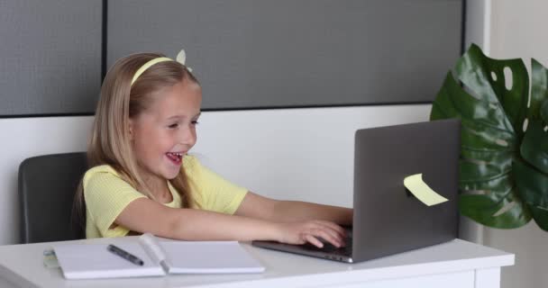 Niña caucásica alumna de la escuela que estudia en línea desde casa, viendo clases en la web o escuchando tutor por video llamada elearning durante coronavirus covid-19 pandemia auto aislamiento. Movimiento lento — Vídeo de stock