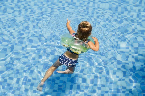 Menina branca pequena feliz com óculos de sol sorrindo alegremente e desfrutando de férias de verão tempo na piscina no hotel resort. Criança com cabelo loiro vestindo roupa de banho durante as férias de verão — Fotografia de Stock