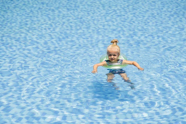 Menina branca pequena feliz com óculos de sol sorrindo alegremente e desfrutando de férias de verão tempo na piscina no hotel resort. Criança com cabelo loiro vestindo roupa de banho durante as férias de verão — Fotografia de Stock