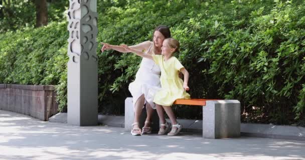 Feliz familia caminando en el parque de verano. Joven Caucásica Madre e hija de siete años pasando tiempo juntas. 4k cámara lenta — Vídeo de stock