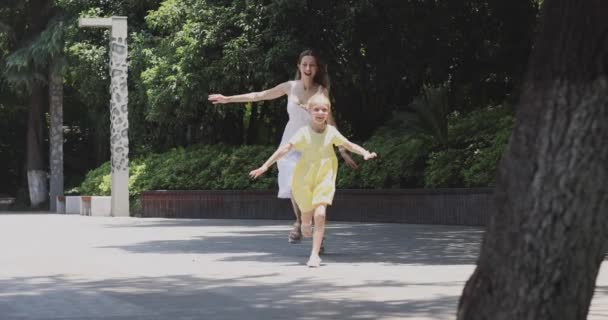 Feliz familia caminando en el parque de verano. Joven Caucásica Madre e hija de siete años pasando tiempo juntas. 4k cámara lenta — Vídeo de stock