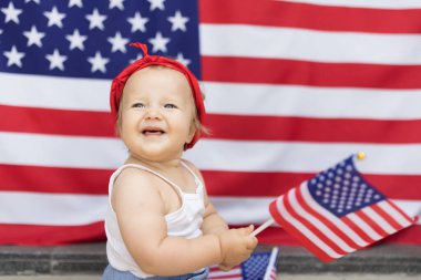 Vatansever bayram. On bir aylık, sarı saçlı, mavi gözlü, evinde Amerikan bayrağı olan sevimli beyaz bir bebek. ABD 4 Temmuz 'da bağımsızlığını kutladı.