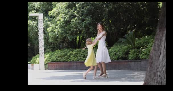 Buona famiglia passeggiando nel parco estivo. Madre e figlia trascorrono del tempo insieme e si tengono per mano all'aperto. 4k rallentatore — Video Stock