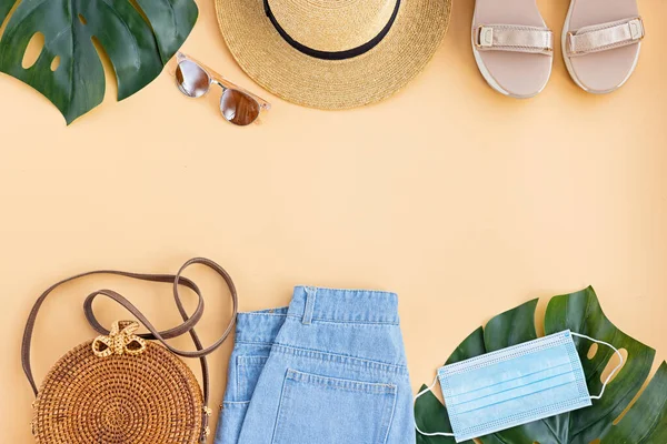 Zomer compositie met vrouwelijke mode outfit. Monstera bladeren, stro hoed, bamboe zak, schoenen, draadloze koptelefoon op pastel achtergrond. Platte lay, bovenaanzicht, overhead, mockup, template, kopieerruimte — Stockfoto