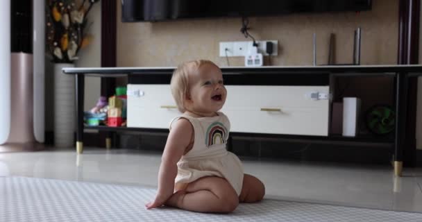 Authentic close up Cute Caucasian Baby Girl 1 ano de idade Jogando no chão na sala de estar em casa. Movimento lento. — Vídeo de Stock