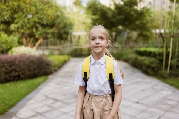 Estudante de volta à escola depois de férias de verão. Aluno de uniforme sorrindo no início da manhã ao ar livre. — Fotografia de Stock