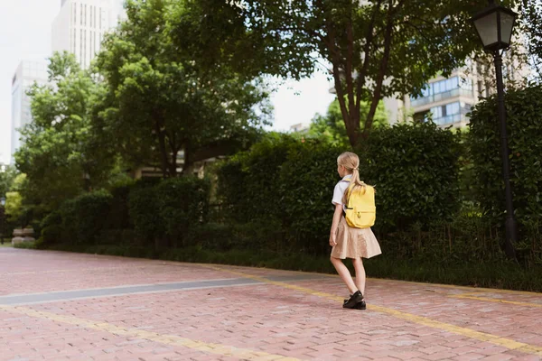 Colegiala de vuelta a la escuela después de las vacaciones de verano. Niño en uniforme sonriendo temprano en la mañana al aire libre. — Foto de Stock