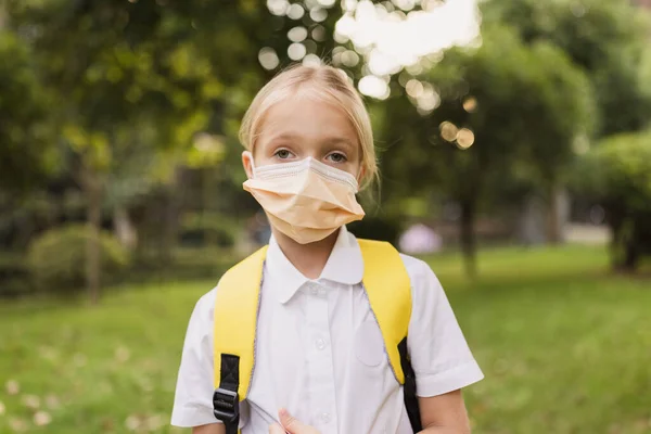 Szkolne dziecko w masce ochronnej podczas epidemii koronawirusa podczas chodzenia do szkoły — Zdjęcie stockowe