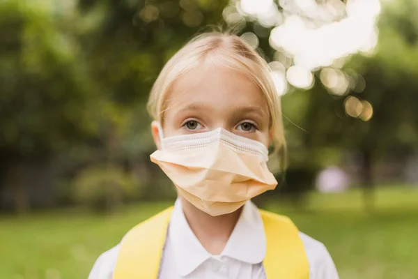 Szkolne dziecko w masce ochronnej podczas epidemii koronawirusa podczas chodzenia do szkoły — Zdjęcie stockowe