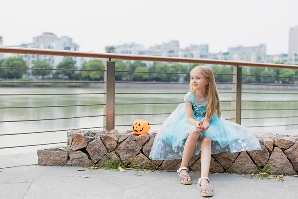 Petite fille blonde en costume de princesse avec lanterne à citrouille dans le parc. Joyeux Halloween concept — Photo