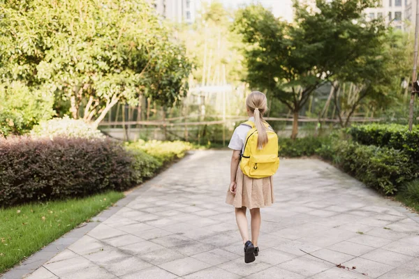 Colegiala de vuelta a la escuela después de las vacaciones de verano. Alumno en uniforme sonriendo temprano en la mañana al aire libre. — Foto de Stock
