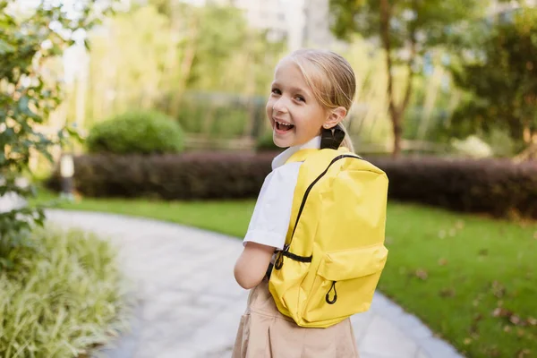 Colegiala de vuelta a la escuela después de las vacaciones de verano. Alumno en uniforme sonriendo temprano en la mañana al aire libre. —  Fotos de Stock