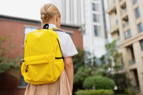 Skolejente tilbake til skolen etter sommerferier. Barn i uniform står oppreist utendørs om morgenen. – stockfoto