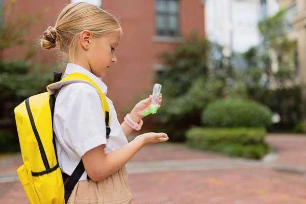 Skolflicka tillbaka till skolan efter sommarlovet. Barn i uniform stående tidigt på morgonen utomhus. — Stockfoto