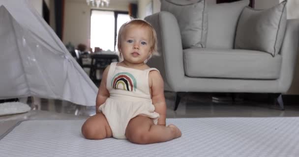 本物のクローズアップかわいい白人の赤ちゃんの女の子1歳自宅のリビングルームで床で遊んでいます。スローモーション. — ストック動画