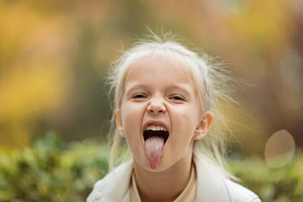 Linda niña elegante con el pelo largo y rubio caminando en el parque de otoño. Moda de otoño para niños. Feliz infancia. Retrato de estilo de vida. Niño caucásico 6 años al aire libre —  Fotos de Stock