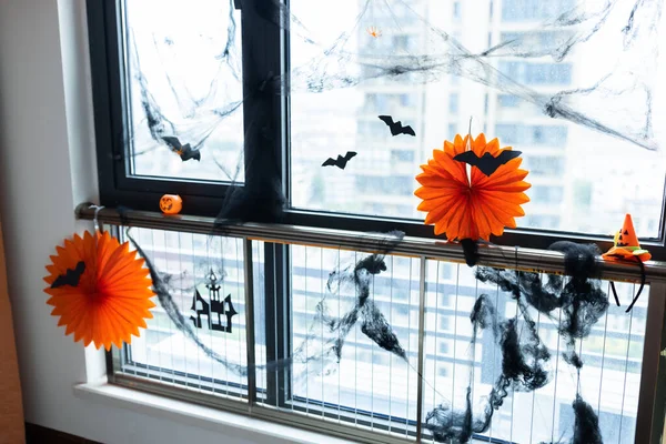 Arredamento domestico per la celebrazione di Halloween con ghirlanda di carta colore arancione, pipistrello sulla finestra — Foto Stock