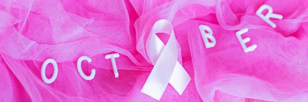 Plochý pohled na slovo říjen s růžovou stuhou - symbol povědomí o rakovině prsu měsíců — Stock fotografie