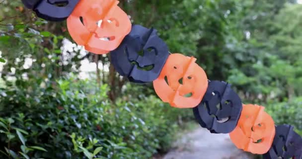 Linda niña caucásica con el pelo rubio de siete años de edad en traje de bruja con vestido naranja negro celebrando Halloween al aire libre en la calle. Concepto de vacaciones. Movimiento lento. — Vídeos de Stock