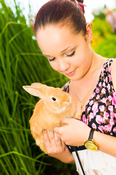 Young woman smiling and holding cute rabbit