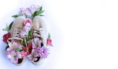 Pembe ve kırmızı alstroemerili bahar kompozisyonu. Çiçekler bej süet ayakkabılardan yetişir. Bahar. Tebrik kartı için arkaplan.