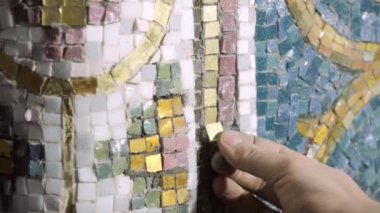 Sanat stüdyosu zanaatkârı altın cam kare mozaik yerleştirdi