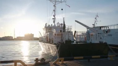 Mavi gökyüzünün altındaki iskeleye demirlemiş vinci olan balıkçı teknesi.