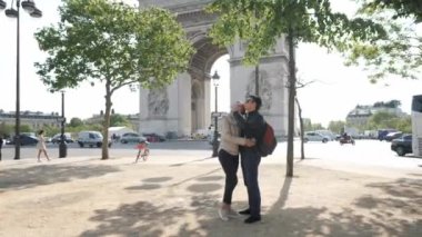 Neşeli eş, Zafer Kemeri yakınlarındaki bahar parkında kocasını kucaklıyor.