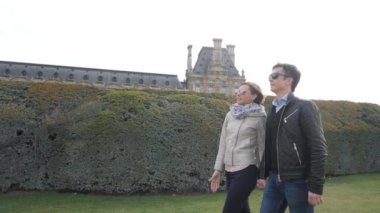 Aile çifti baharda Tuileries bahçesinde yürüyor.