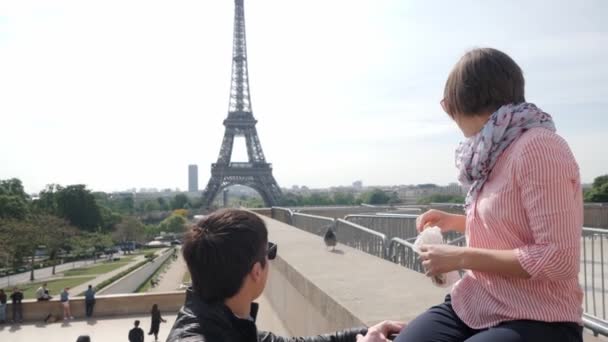 Женщина кормит голубей, проводя время с парнем в Париже — стоковое видео