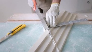 Eldivenli tamirci dekoratif alçı işçiliği kesti.