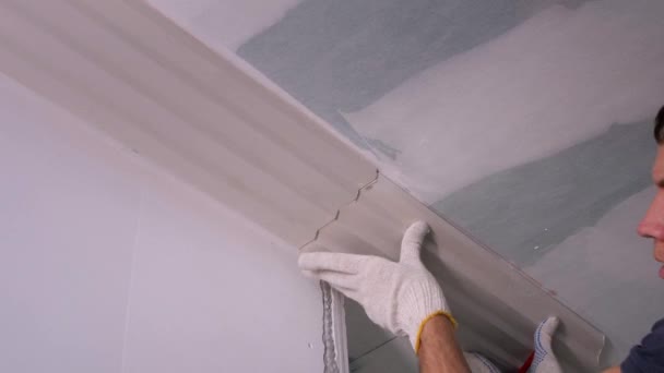 Trabalhador coloca fretwork no teto e faz marcas com lápis — Vídeo de Stock