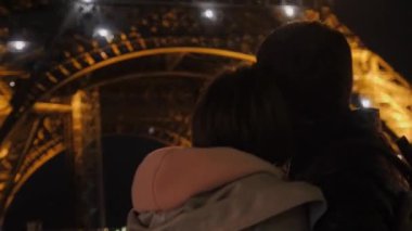 Aile kucaklaşması Eyfel Kulesi 'nde lazer gösterisinin keyfini çıkarıyor.