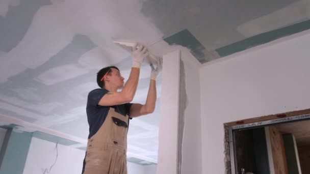 Builder puts plaster on ceiling in room with empty doorway — Stock Video