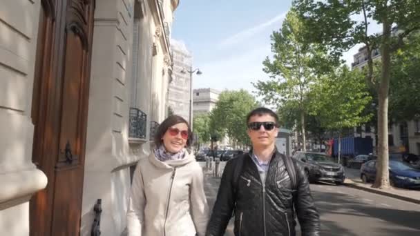 Feliz hombre y mujer caminan uniendo sus manos a lo largo de la calle Paris — Vídeo de stock