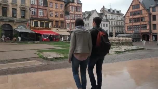 Homme et femme marchent main dans la main le long de la célèbre place Rouen — Video