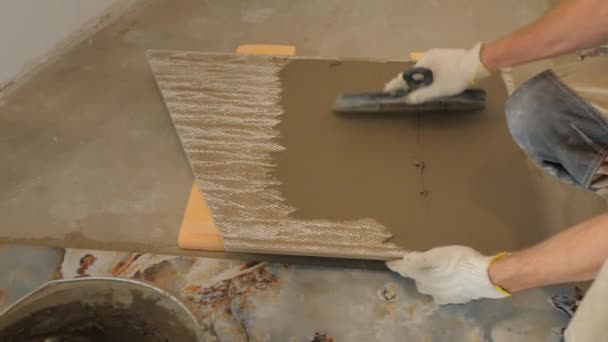Handyman em luvas emplastros telha cerâmica com faca drywall — Vídeo de Stock