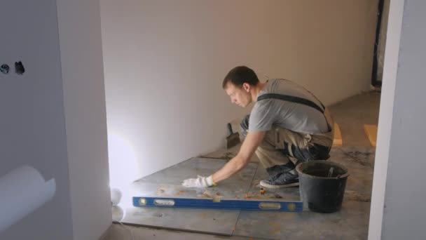 Arbeiter fixiert Marmorfliese auf Fußboden neben Wand — Stockvideo