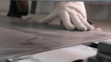 Beyaz pamuk eldiven giyen tamirci seramik paneli keser