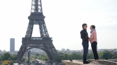 Eiffel Kulesi 'nin yakınında el ele tutuşan sevimli çift öpücükleri