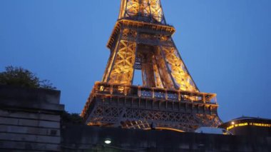 Muhteşem Eyfel Kulesi, Paris 'te altın ışıkla aydınlatılmış.
