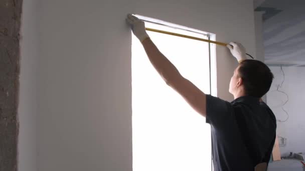Handyman toma medidas con cinta metálica autorretráctil — Vídeos de Stock