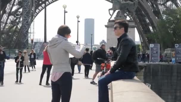 Frau liest Papiermann ruht auf Brüstung nahe Eiffelturm — Stockvideo
