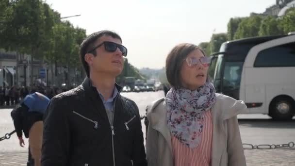 Pareja con gafas de sol mira el turismo en la calle Paris — Vídeo de stock