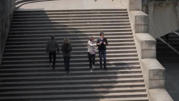 Boyfriend feeds beloved woman going down large old steps — Stock Video